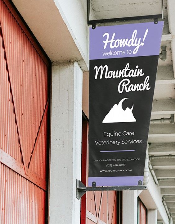 A sample banner hanging outside a red barn. The banner is black with a slate blue border and features a farm-inspired graphic.