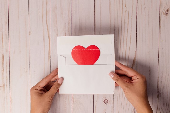 hands holding envelope with heart on it