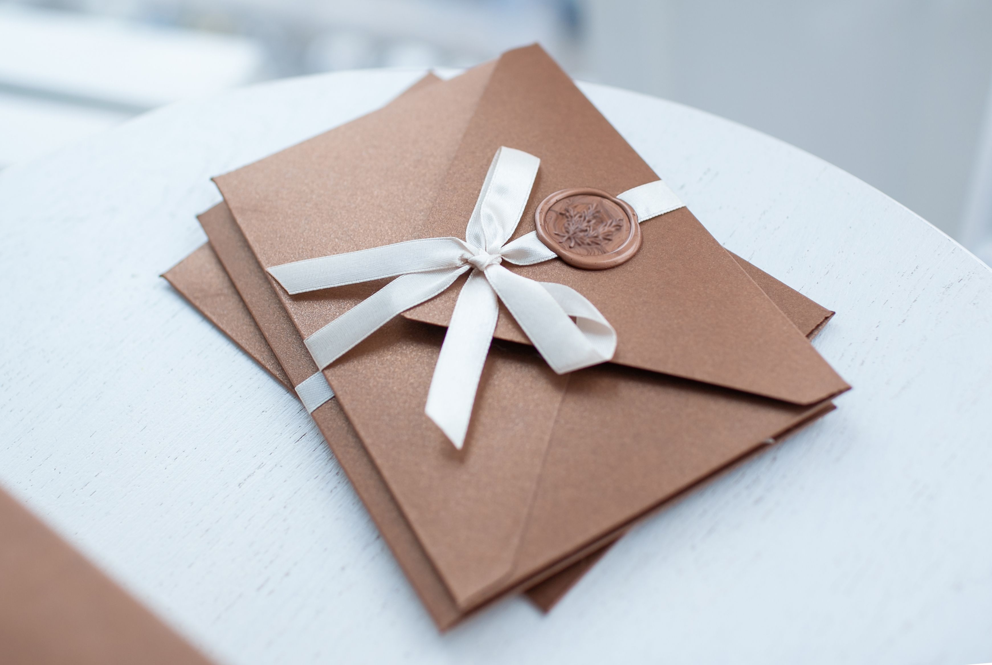 stack of brown envelopes with a ribbon